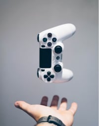 a hand tossing and playstation controller in the air